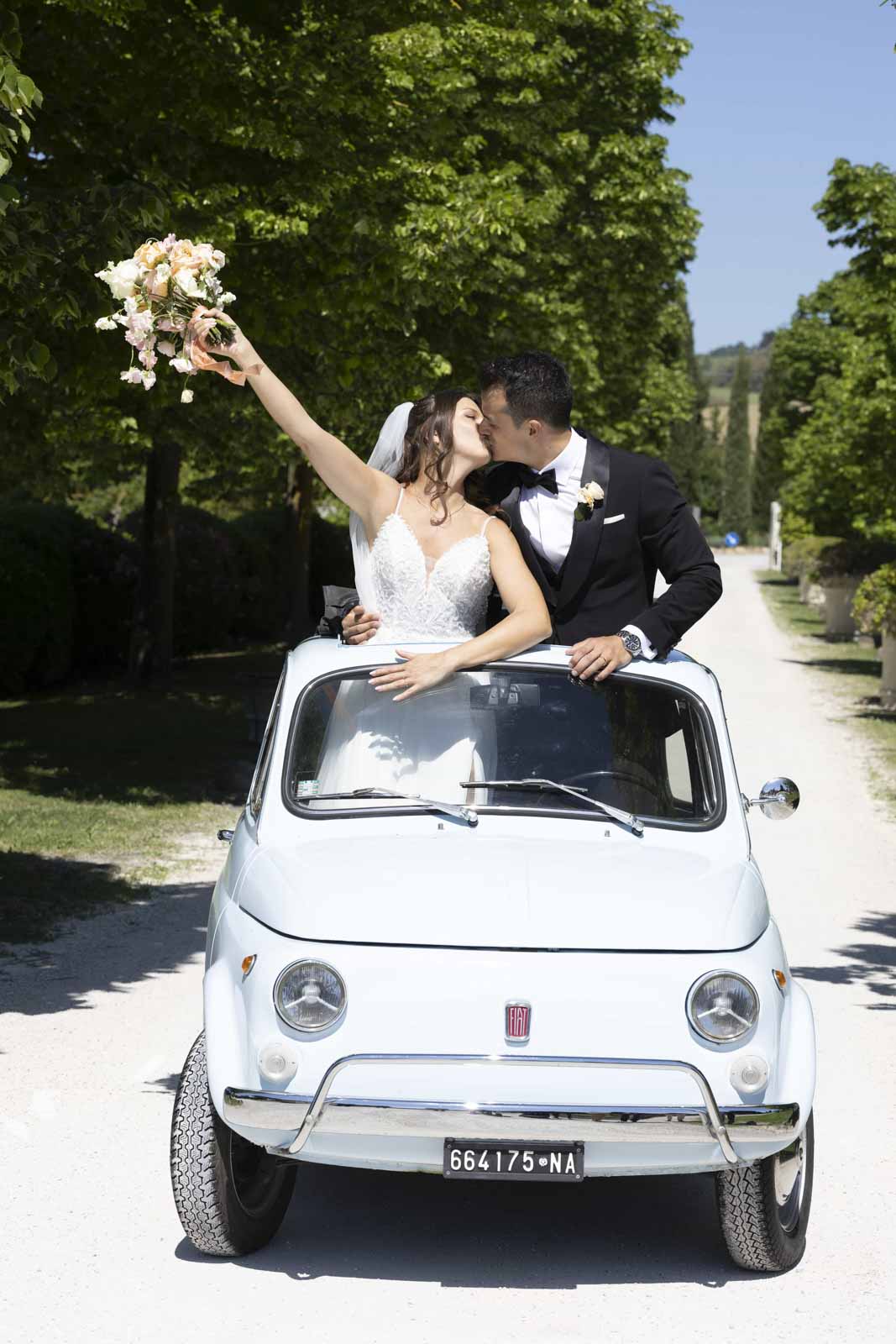 Wedding in a Charmin Umbrian Borgo and the newlyweds kissing on the 500